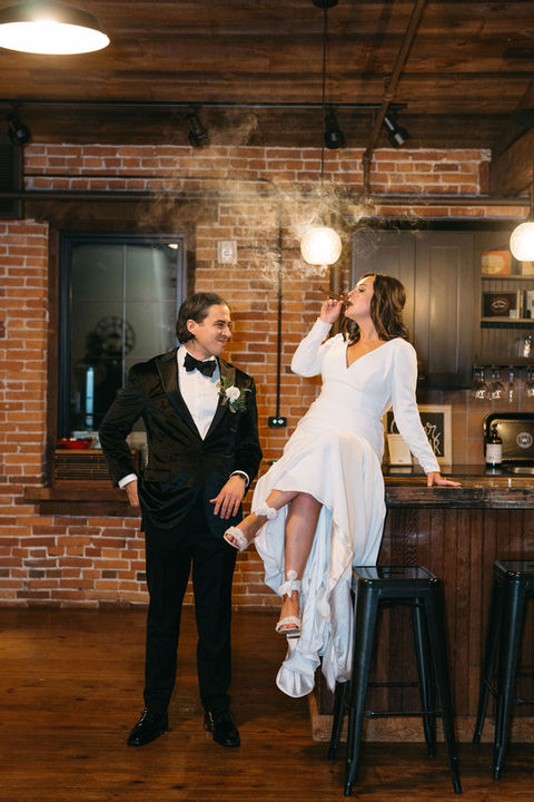 Stylish bride and groom smoking cigars