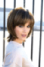 Front view of Mid length, layered wig with fringe.