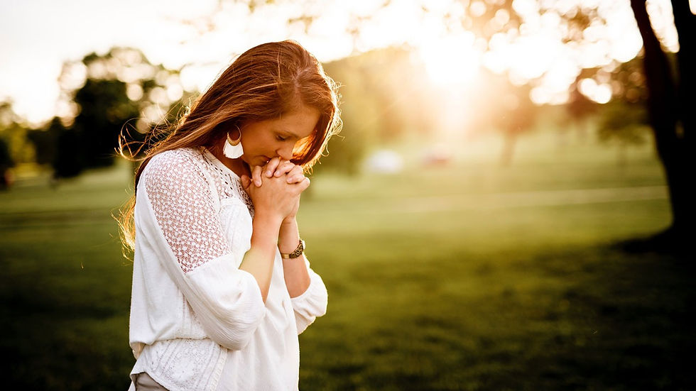 A woman praying outside.