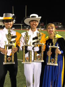students holding trophies at marching band competition