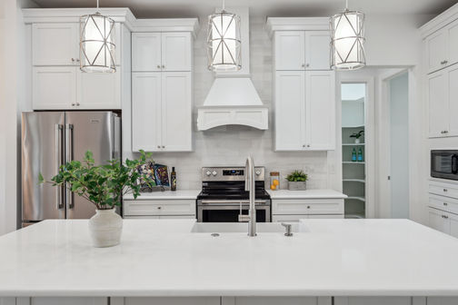 Modern kitchen with white cabinets and stainless steel appliances.