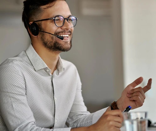 agente-de-call-center-feliz-usando-computador-enquanto-se-comunica-com-clientes-e-trabalha