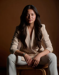 business portrait of confident woman seated in business suit and staring straight at camera