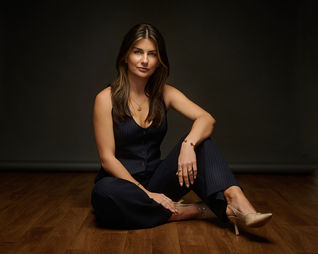 confident real estate agent teide grice posed sitting on floor for dark and moody business portrait