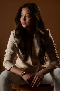 business portrait of confident woman seated in business suit and looking off camera