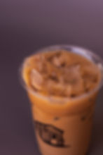Iced coffee in a clear plastic cup with ice cubes.