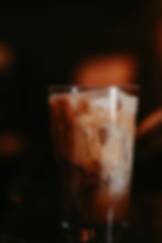 Iced coffee with swirling cream in a glass.