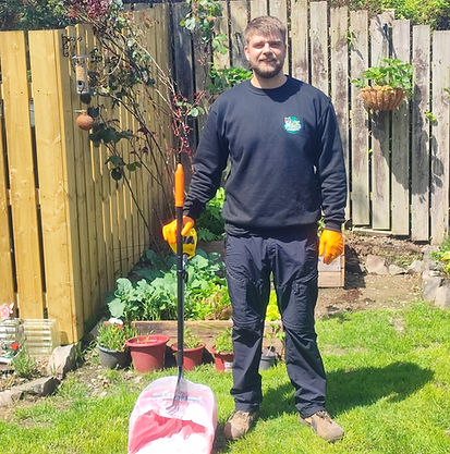 Sebastien from Pick-a-Doo holding professional dog waste removal equipment in a clean residential garden in Bangor, Northern Ireland.