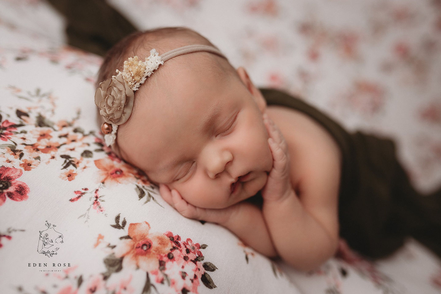 Newborn girl hands on face side lying pose