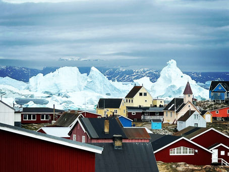 Guests enjoying a crisp September afternoon at Camp Kiattua in Greenland, wearing comfortable outdoor layers while overlooking the fjord, showing that autumn travel is cool but not extremely cold.
