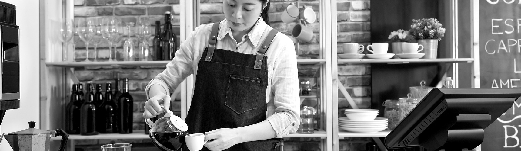 barista pouring milk to the coffee cup