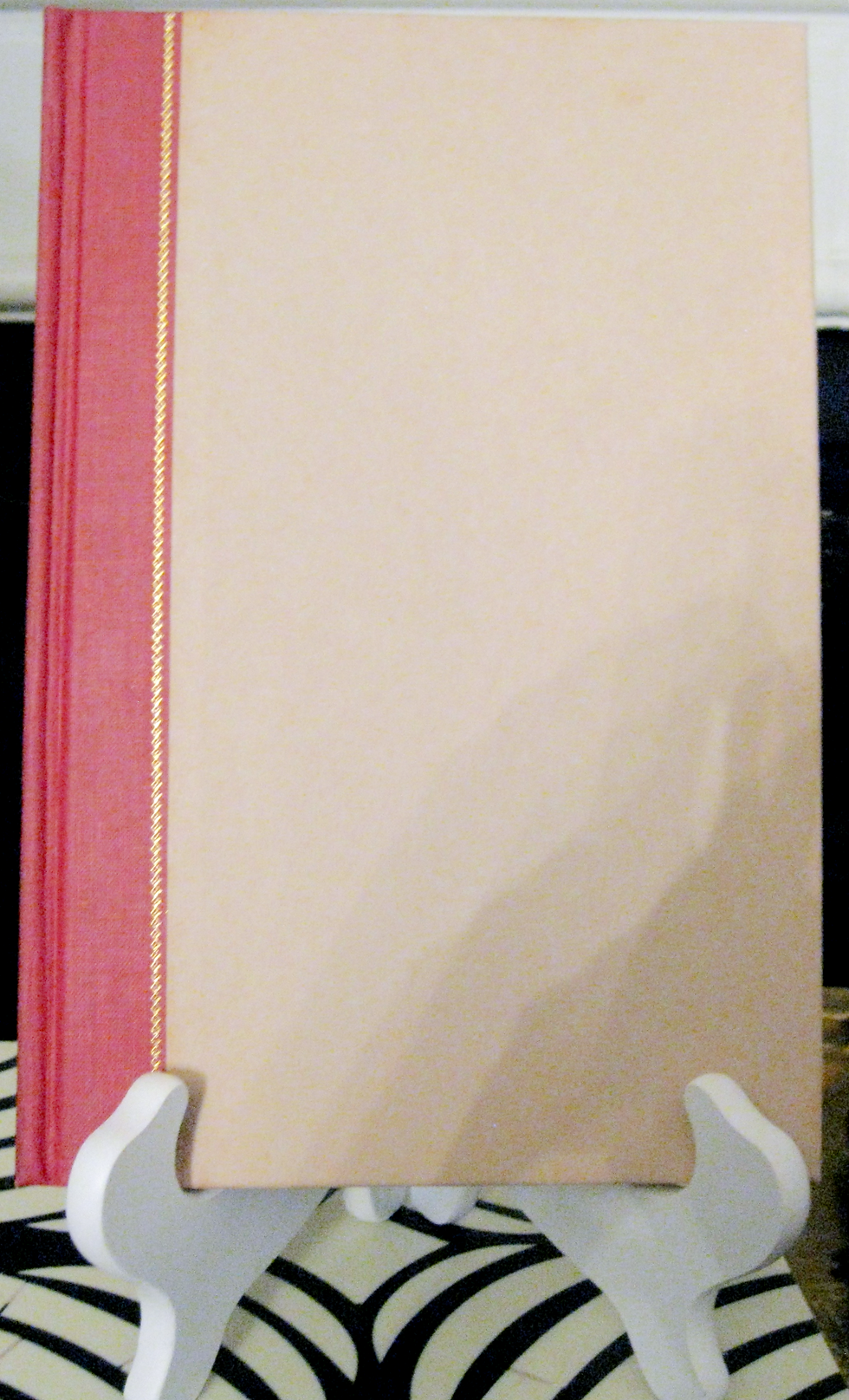 Thumbnail: cream boards with a red linen spine with/ gold lettering