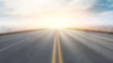 夕暮れ時の空のアスファルト道路とパノラマの街のスカイラインと建物