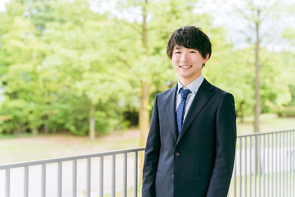 新緑と笑顔の若いビジネスマン