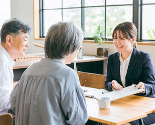 夫婦と打ち合わせするファイナンシャルプランナー