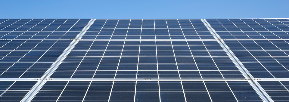晴天の直射日光を浴びる太陽光パネル発電システム屋根設置と青空白い雲ECOエネルギー電力自由化イメージ