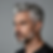 Photorealistic studio portrait of a mature man with natural silver hair styled in a clean fade, gray on top with darker tapered sides, sharp beard outline, confident expression, neutral gray backdrop, luxury men’s grooming photography, ultra-detailed realism