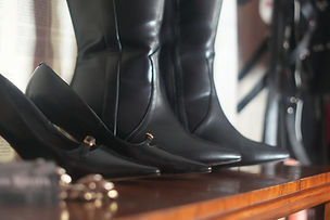 Thigh-high leather boots displayed in Mistress Kaizen's Lisbon dungeon
