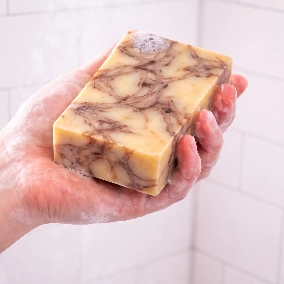 Luz Cobriza Bar Soap — single bar shown in use