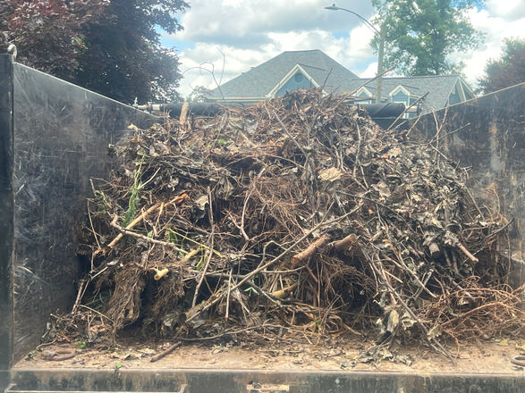 12-yard dumpster rental filled with brush, branches, and yard debris from a residential cleanup project in Brookstone Country Club, Acworth, GA.