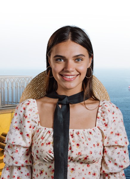 Mujer sonriente con sombrero de paja, cerca del mar