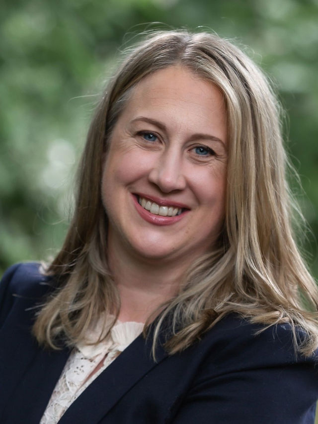 Jessica Kuchan, attorney, blonde woman smiling wearing a blue blazer