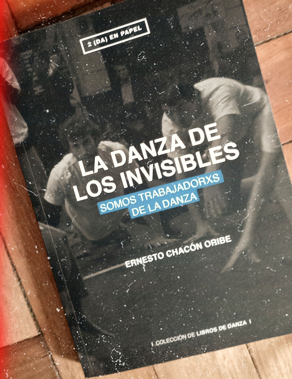 Portada del libro "La danza de los invisibles" de Ernesto Chacón Oribe, que dice "Somos trabajadores de la danza". El fondo es oscuro y hay imágenes de personas en movimiento.
