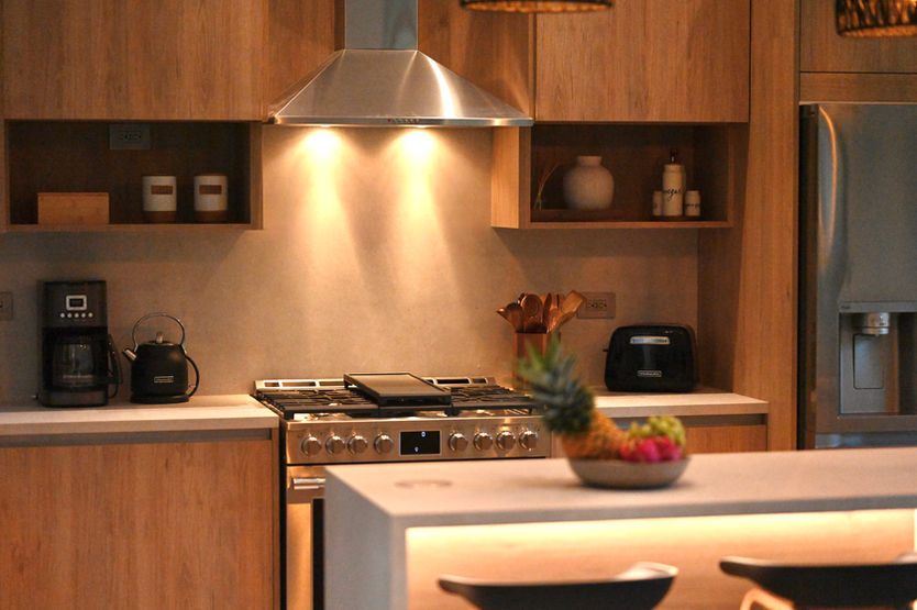 Contemporary kitchen with island, wood cabinetry, and garden views at Casa Valley in Playa Venao.