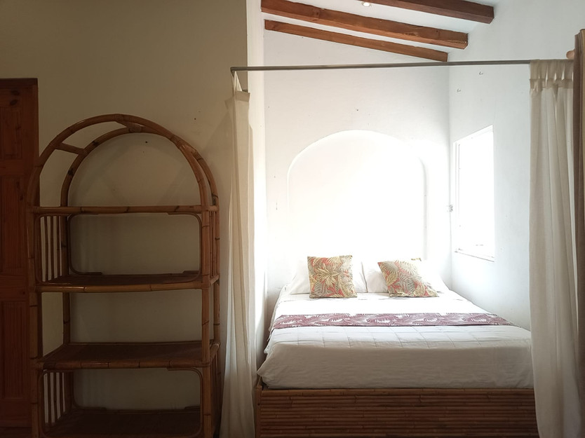 Bright apartment with double bed, seating area and ceiling fan at Villas del Sol