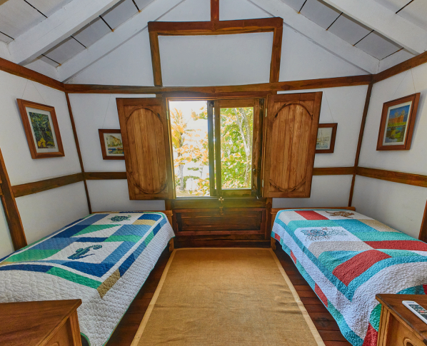 Twin guest bedroom with wood finishes and natural light at oceanfront estate in Los Destiladeros, Pedasí.