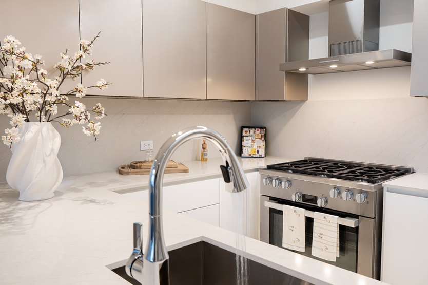Bright modern kitchen in The Palms model apartment with large work surfaces, integrated storage, and premium appliances