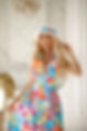 beautiful-sweet-blonde-woman-in-bright-outfit-long-skirt-with-flower-print-wavy-hairstudio