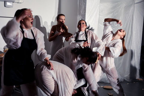 Intense theatrical scene: women in white, dramatic action