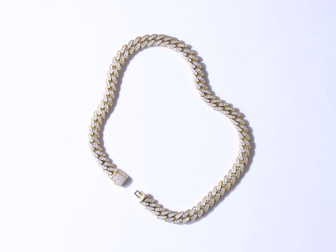 Elegant pearl necklace with gold clasp displayed on soft white surface, captured in a refined jewellery photography setup.
