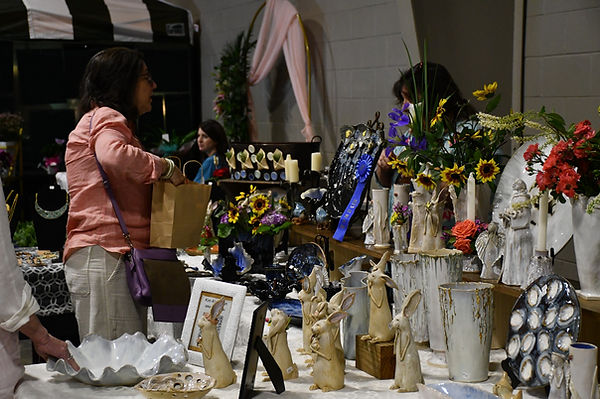 Patron looks at pottery at the Arts & Crafts Expo