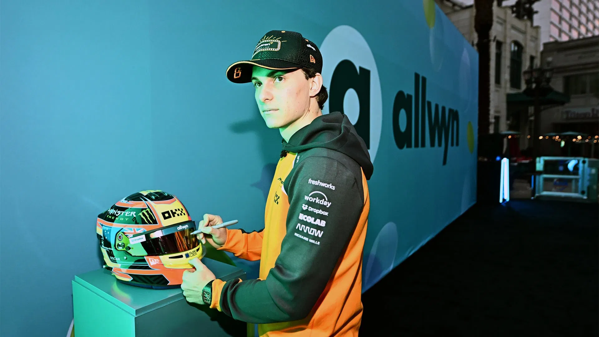 Allwyn McLaren Scratch Car Instagram social media post showing Oscar Piastri with papaya F1 car panels and blue branding during Las Vegas Grand Prix 2025 giveaway - JC Rubio emcee event