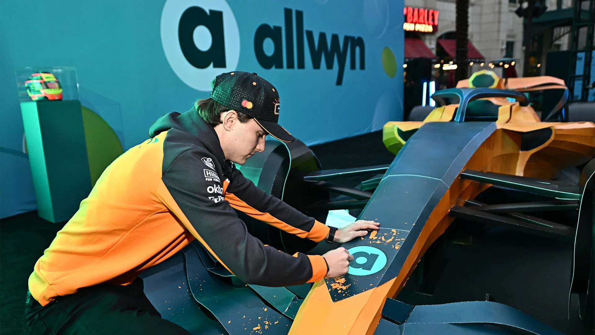 Allwyn McLaren Scratch Car Instagram social media post showing Oscar Piastri with papaya F1 car panels and blue branding during Las Vegas Grand Prix 2025 giveaway - JC Rubio emcee event