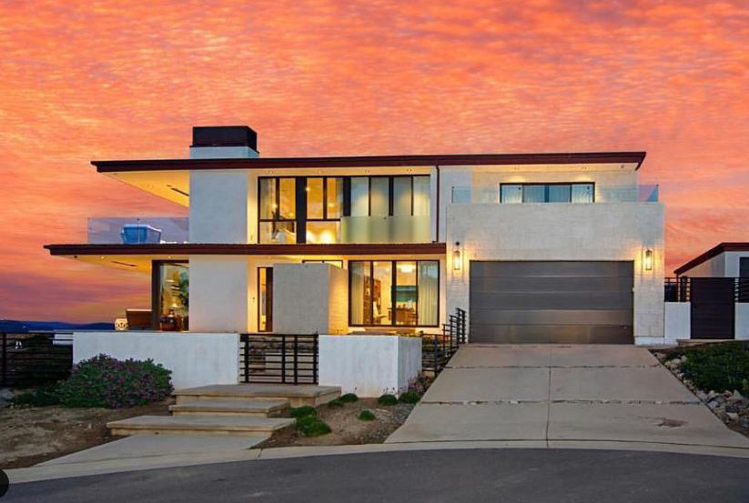 Front of Rawl house in Solana Beach, California designed and built by Trace Wilson Architect with backdrop of beautiful orange sky from sunset.