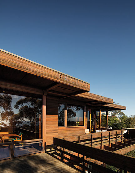 View along front side of this Mid-Century Modern home shows the beautiful redwood siding and graceful roofline.