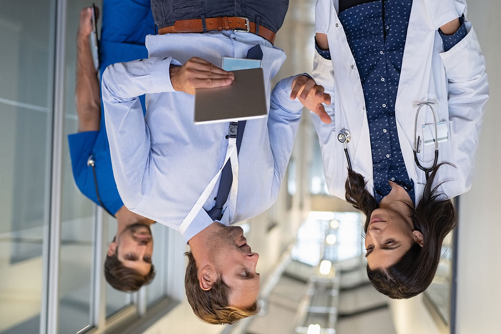 A female doctor in a white  coat with a stethescope around her neck and a male doctor holding a tablet consult on treatment options for a stroke patient