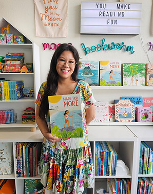 Chloe Ito Ward stands inside the store Small Fry in front of a bookshelf holding her picture book Made for More