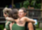 Two women embrace at a retreat, sharing connection and healing after an intuitive bodywork session.