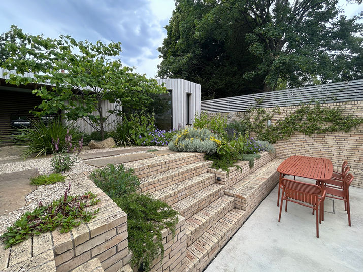 An angled view of brick retaining walls forming multiple planting tiers.