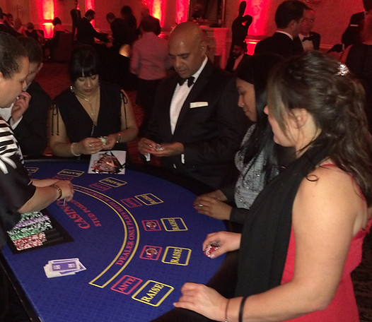 Guests playing Caribbean Stud Poker at a Midland Casino Hire event