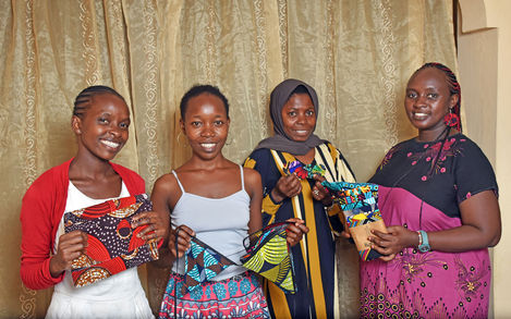Kabisa tailoring team with Rosie, Operations Manager, holding Kabisa brightly coloured products