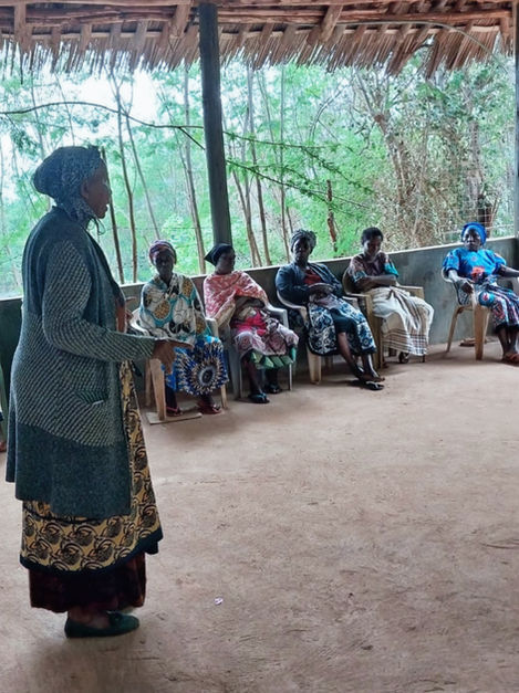 Mama Mercy with five other ladies sat on chairs having a meeting