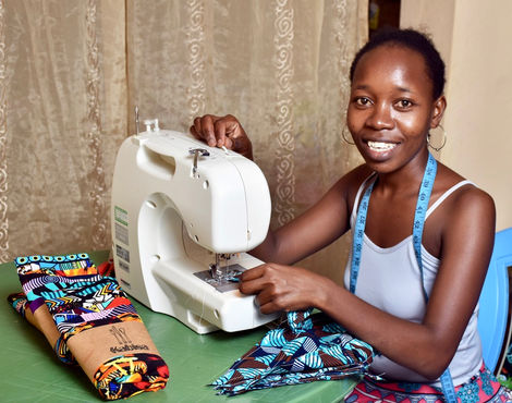 BiChao sat at a table making bunting with her sewing machine donated by Bath Share and Repair