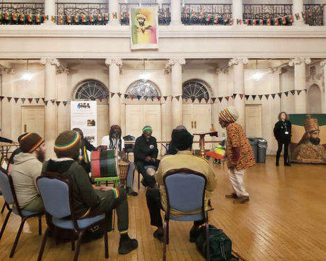 Our bunting in the background at Freedom in the City event at Bath Assembly Rooms in association with Fairfield House CIC. Rastafarian drummers sit in a circle ready to play