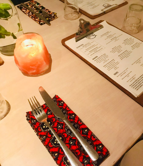 Colourful napkins on a cream coloured table with a crystal candle giving light