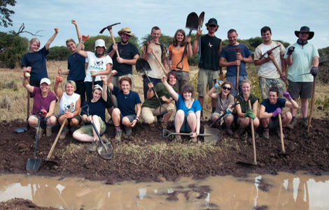 Vics and her expedition group by a body of water they have dug out to create a watering hole for wildlife